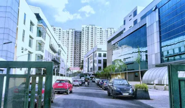 AKR Tech Park AKR Tech Park, Bangalore — office blocks either side of the internal access road, with parked cars and the gate in the foreground