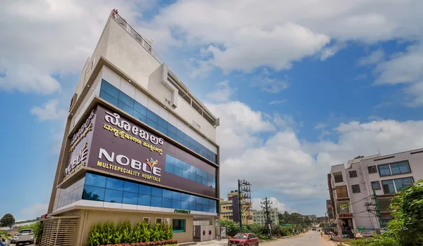 Noble Multispecialty Hospital Noble Multispeciality Hospitals, Bangalore — glass-fronted hospital building with the hospital name in Kannada and English on its street elevation