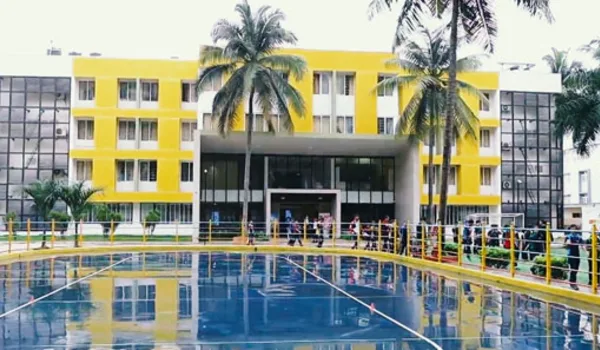 VIBGYOR High School Bannerghatta VIBGYOR High School Bannerghatta, Bangalore — yellow and grey four-storey school block behind the campus swimming pool